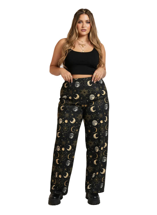 Woman wearing Whimsigoth celestial wide leg lounge pants with sun, moon, and star print.