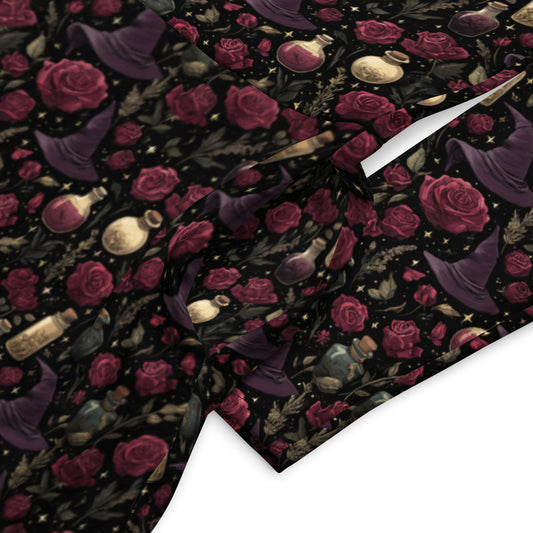 Patterned fabric with red roses, bottles, and other elements on a black background