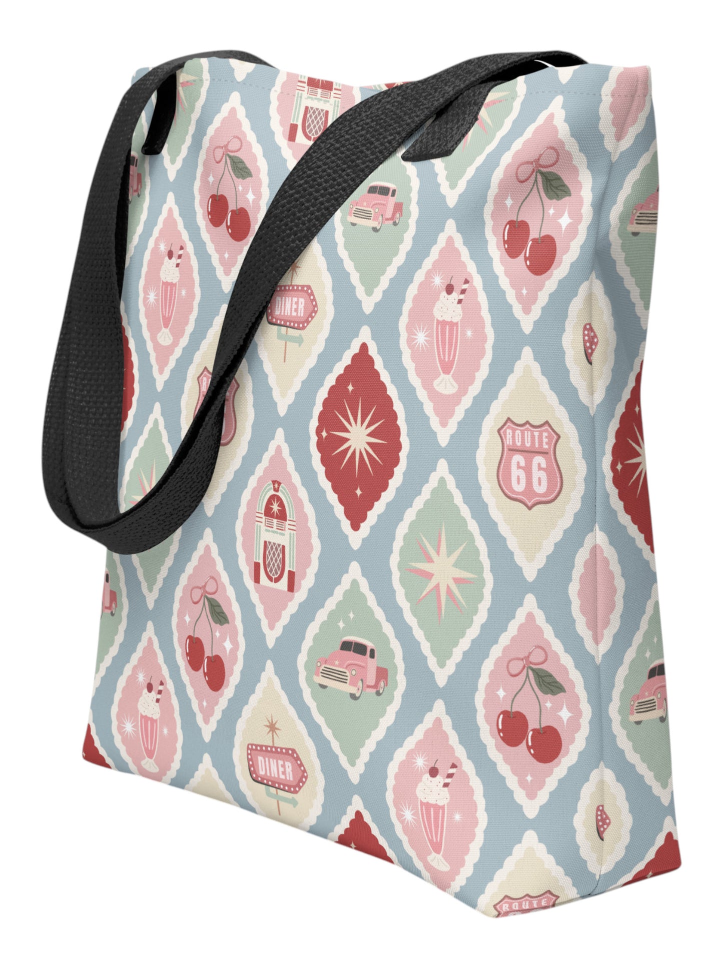 1950s diner retro tote bag with pastel pinup pattern featuring cherries, milkshakes, and jukeboxes on a light blue background with black straps.