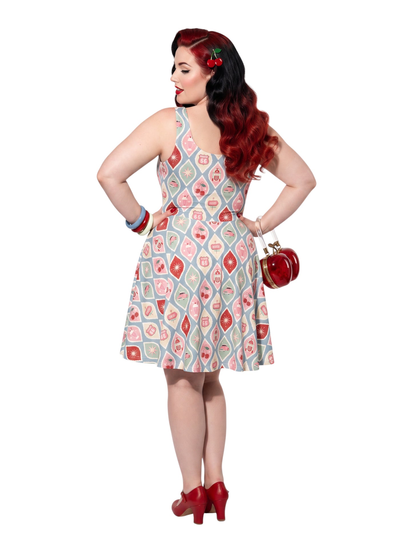 Plus size pinup woman wearing a 1950s style cherry diner milkshake pattern swing dress made of high stretch fabric