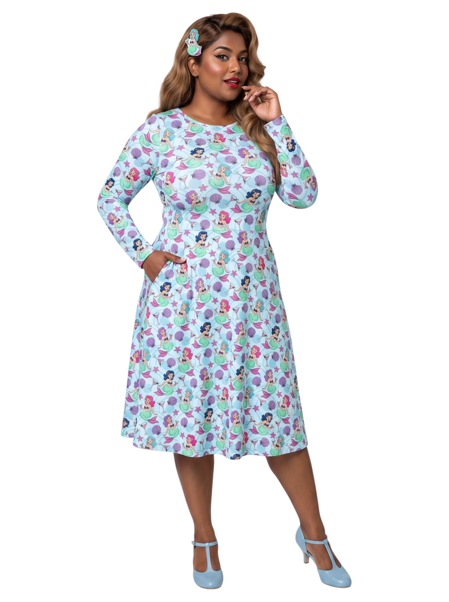 Plus size woman wearing light blue Mermaids and Martinis long sleeve pinup dress with pockets.