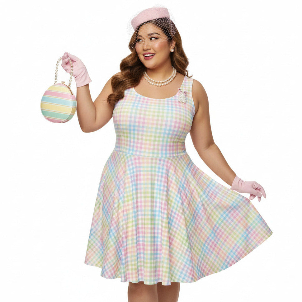 Plus size woman wearing a pastel rainbow gingham 1950s vintage-inspired swing dress with a pink pillbox hat and pearl necklace.
