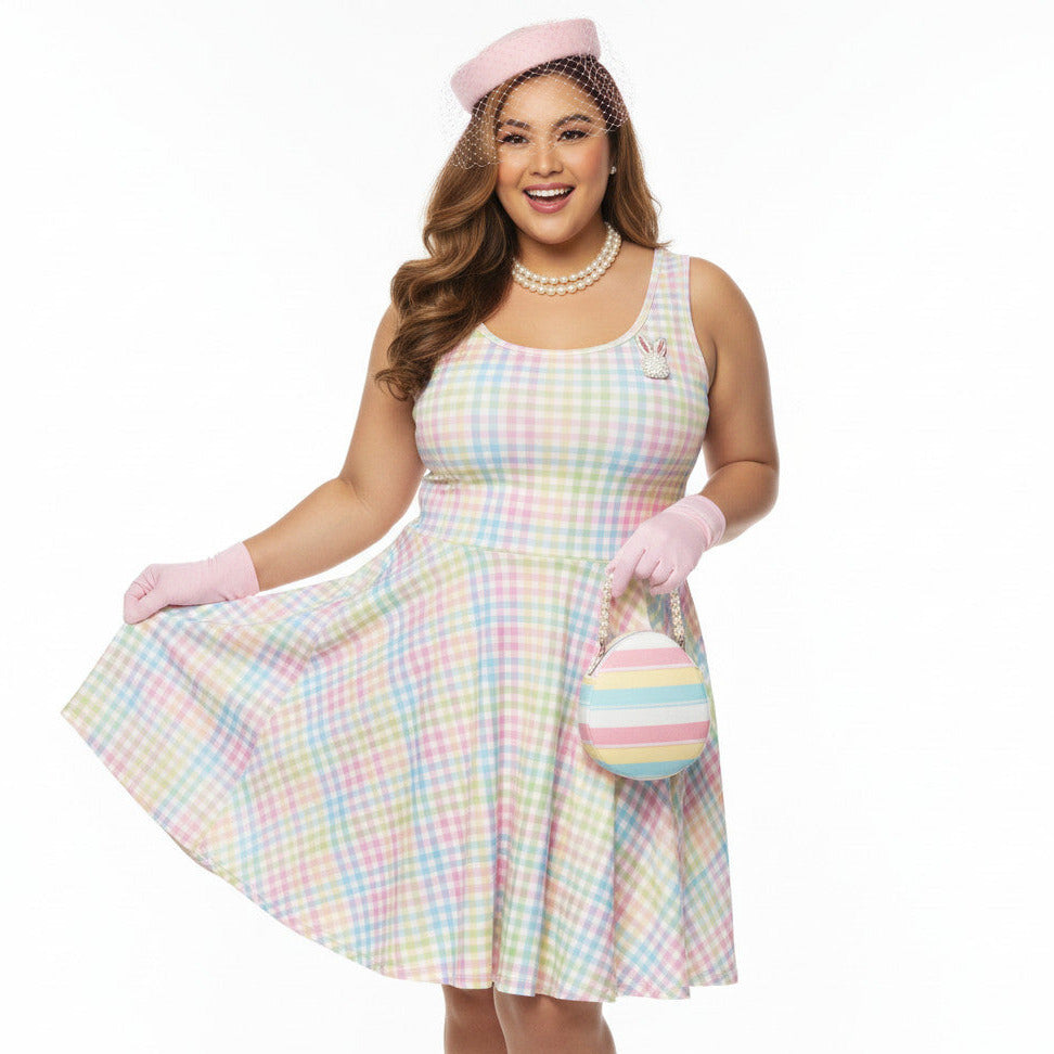 Plus size woman wearing a pastel rainbow gingham 1950s vintage-inspired swing dress with a pink pillbox hat and pearl necklace.