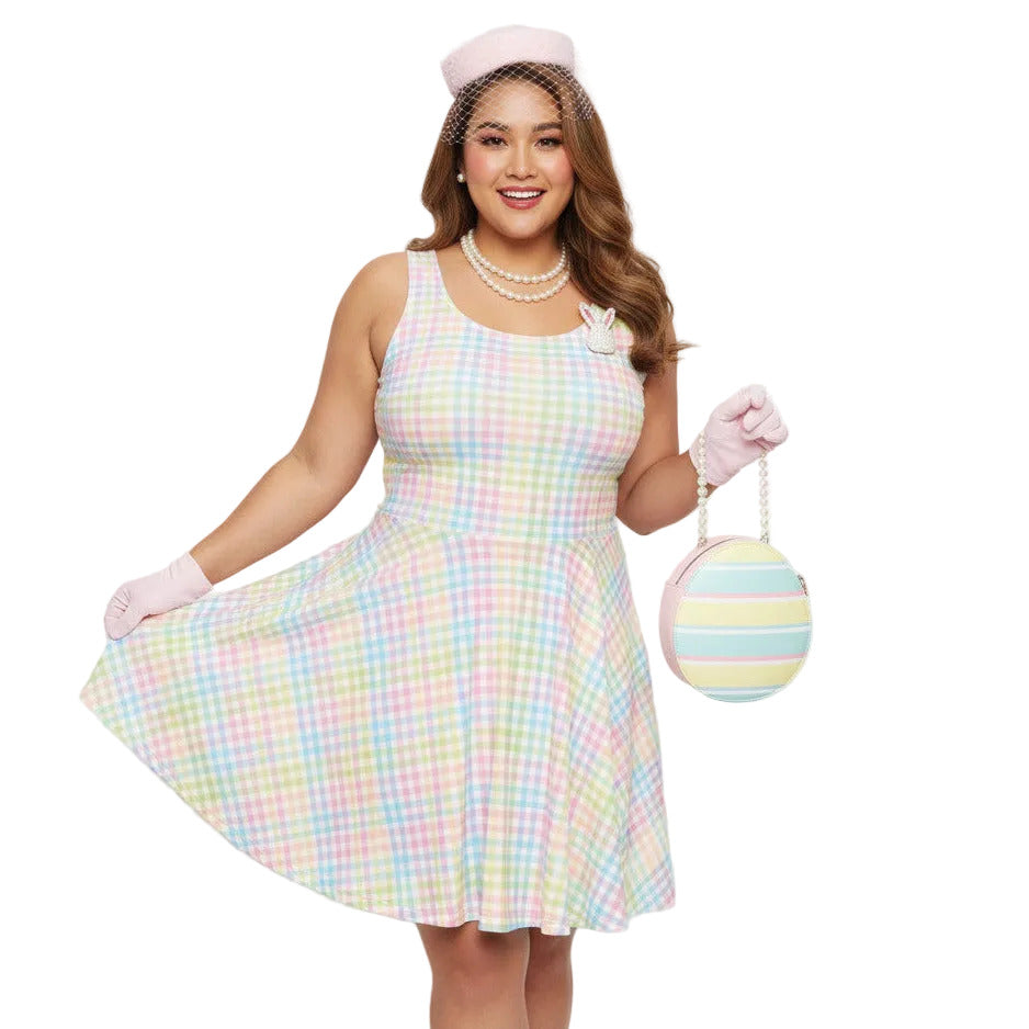 Plus size woman wearing a pastel rainbow gingham 1950s vintage-inspired swing dress with a pink pillbox hat and pearl necklace.