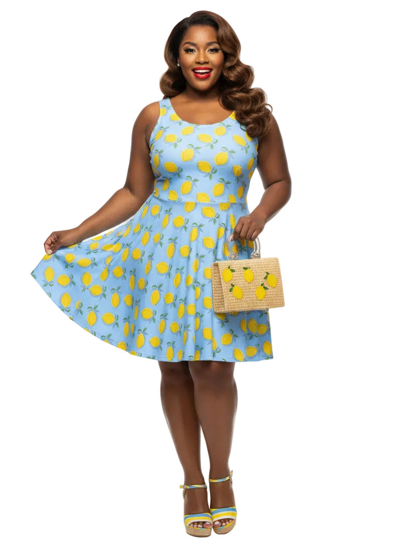 Plus size woman in blue lemon print vintage 50s swing dress with fit and flare silhouette.