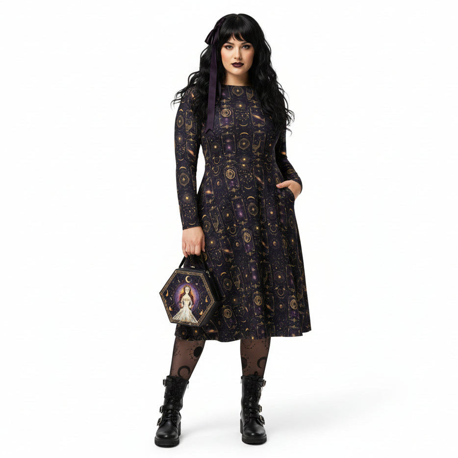 Woman wearing a celestial patterned dress holding a matching handbag on a white background