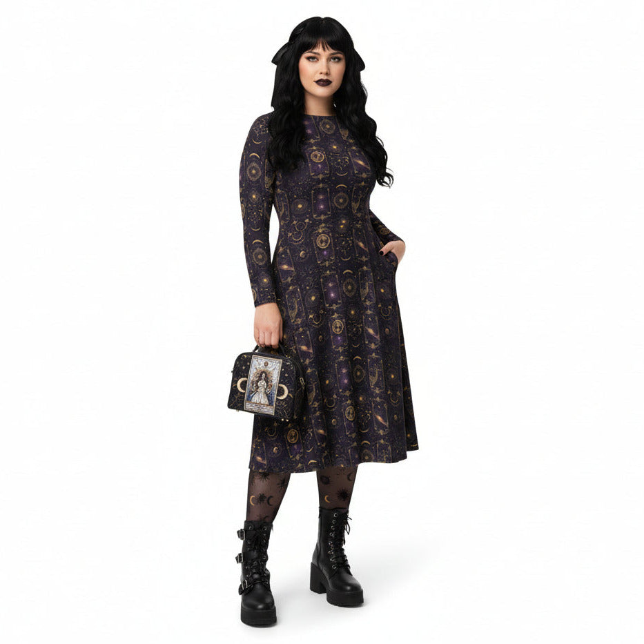 Woman wearing a celestial patterned dress holding a matching handbag on a white background