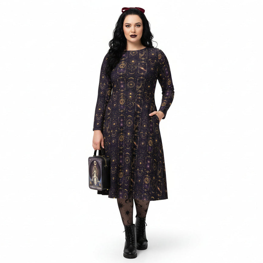 Woman wearing a celestial patterned dress holding a matching tarot card handbag on a white background