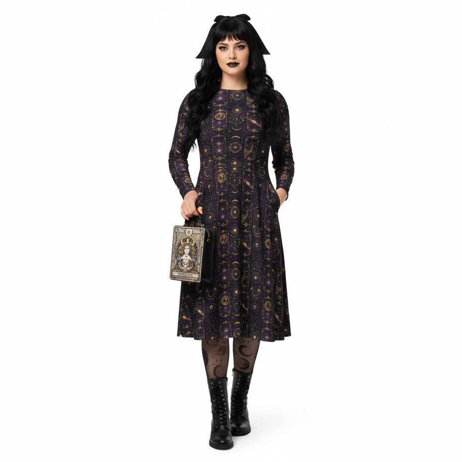 Woman wearing a dark celestial patterned dress holding a tarot card bag on a white background