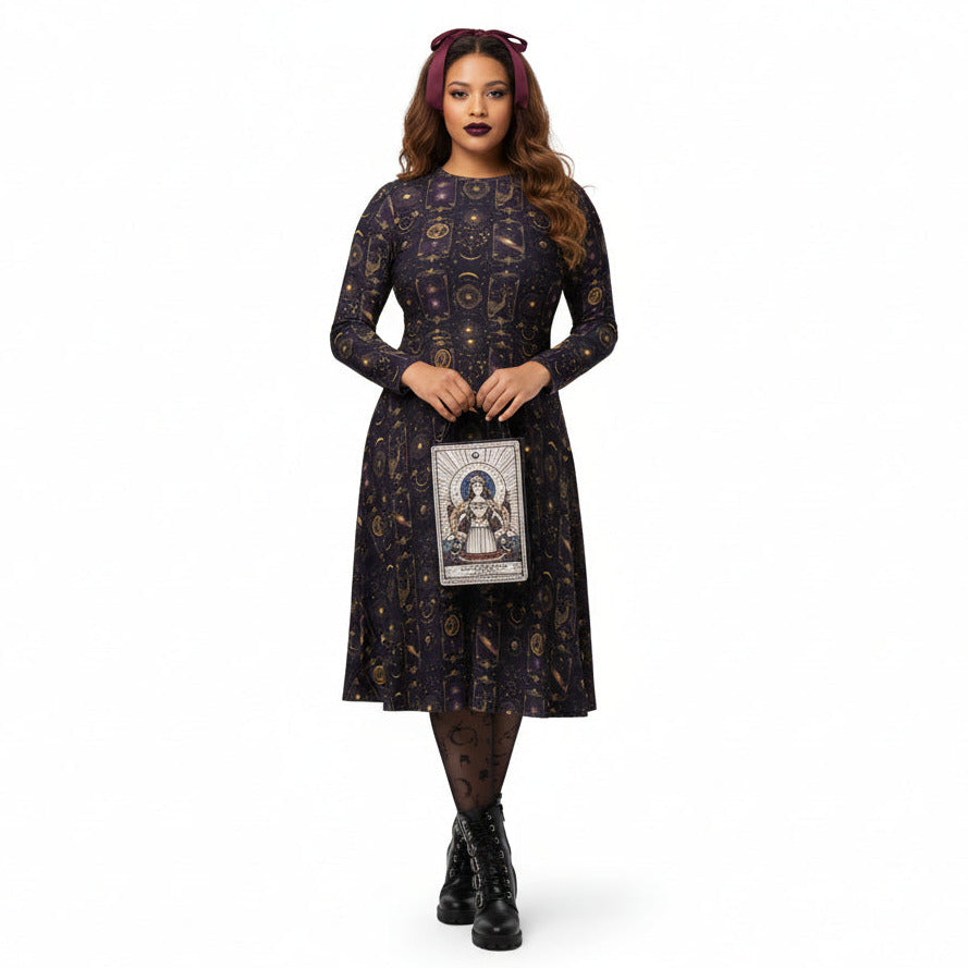 Woman wearing a celestial patterned dress holding a tarot card purse on a white background