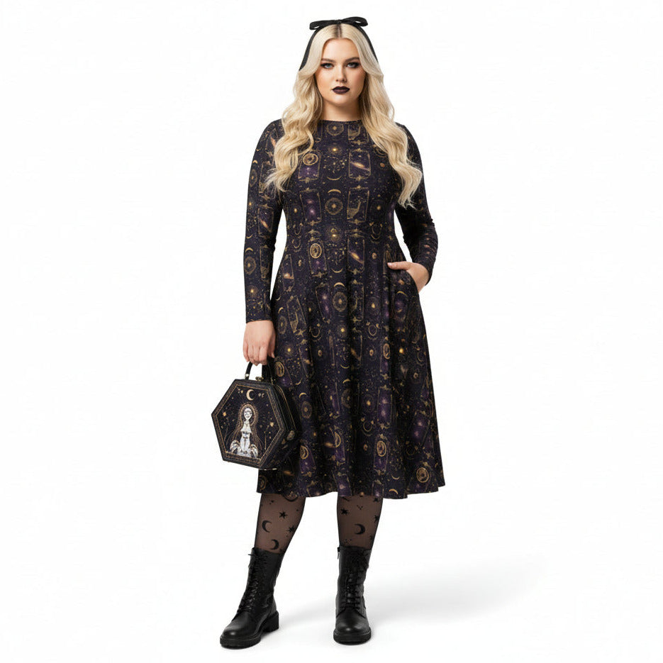 Woman wearing a celestial patterned dress holding a matching tarot card handbag on a white background