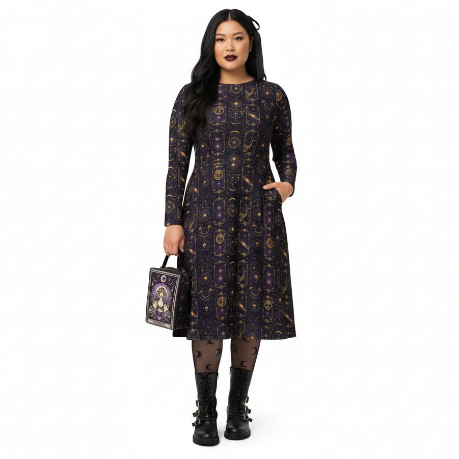 Woman wearing a celestial patterned dress holding a matching tarot card handbag on a white background