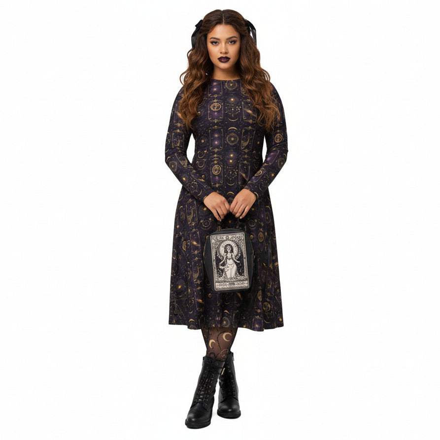 Woman wearing a dark celestial patterned dress holding a bag with a tarot card goddess on a white background