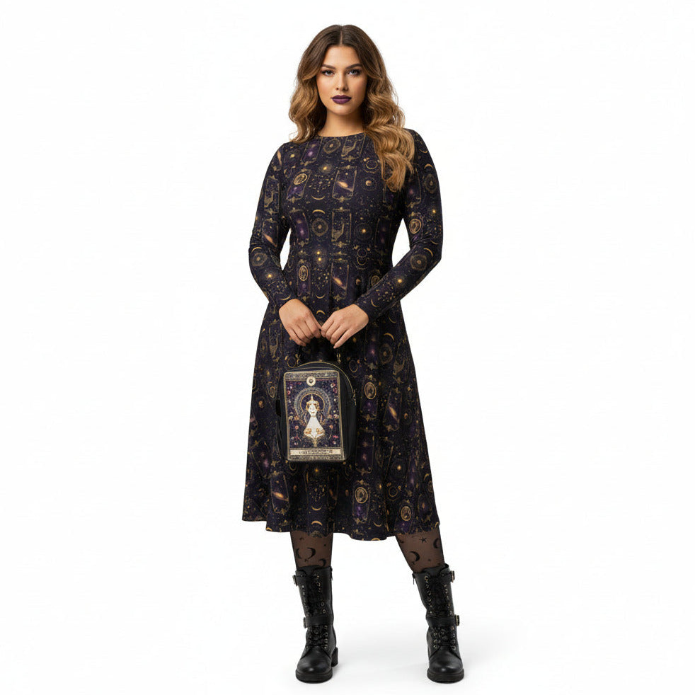 Woman wearing a dark celestial patterned dress holding a matching tarot card bag on a white background