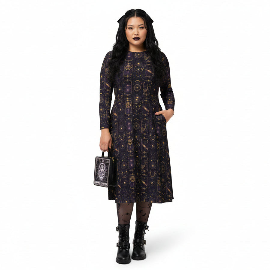 Woman wearing a celestial patterned dress holding a matching handbag on a white background