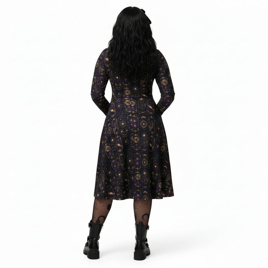 Person wearing a celestial patterned black dress with gold patterns on a white background