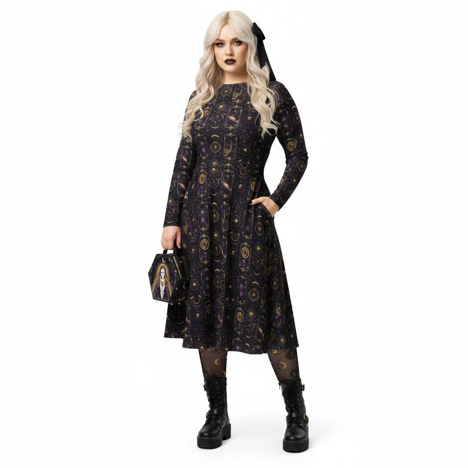 Woman wearing a celestial patterned dress with a matching tarot card handbag on a white background