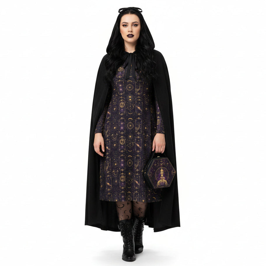 Woman wearing a black cape and celestial patterned dress on a white background