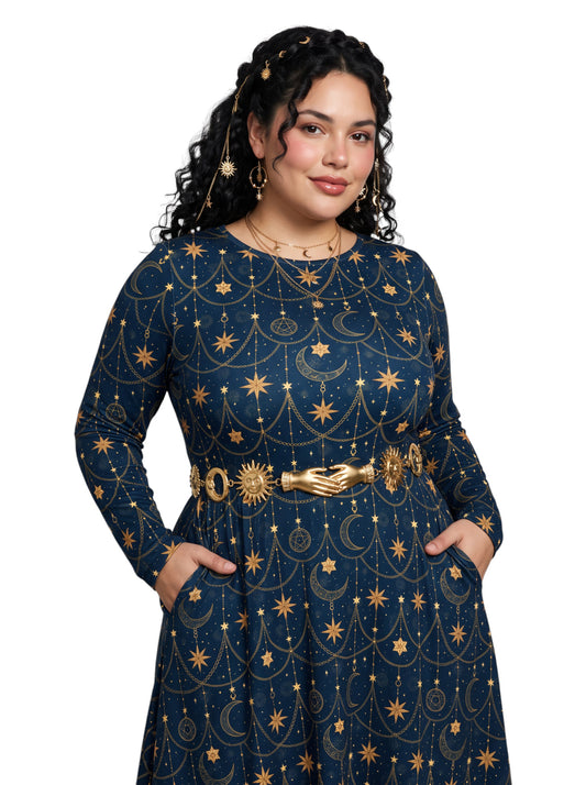 A woman modeling a long-sleeve navy blue dress with a gold celestial print of stars, moons, and suns, accessorized with a gold hand-shaped belt, against a plain white background.