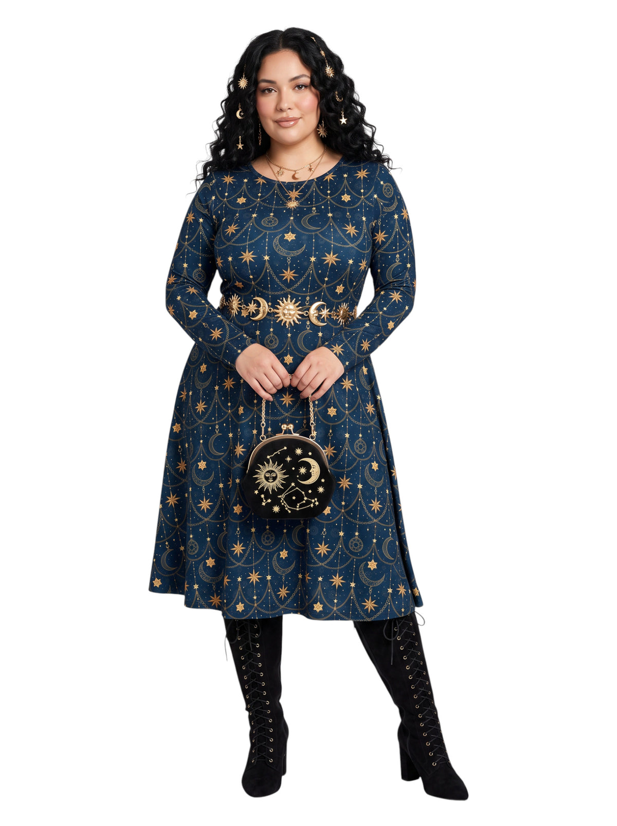 A woman modeling a long-sleeve navy blue dress with a gold celestial print of stars, moons, and suns, styled with a matching belt, a small black and gold patterned handbag, and black lace-up boots against a plain white background.