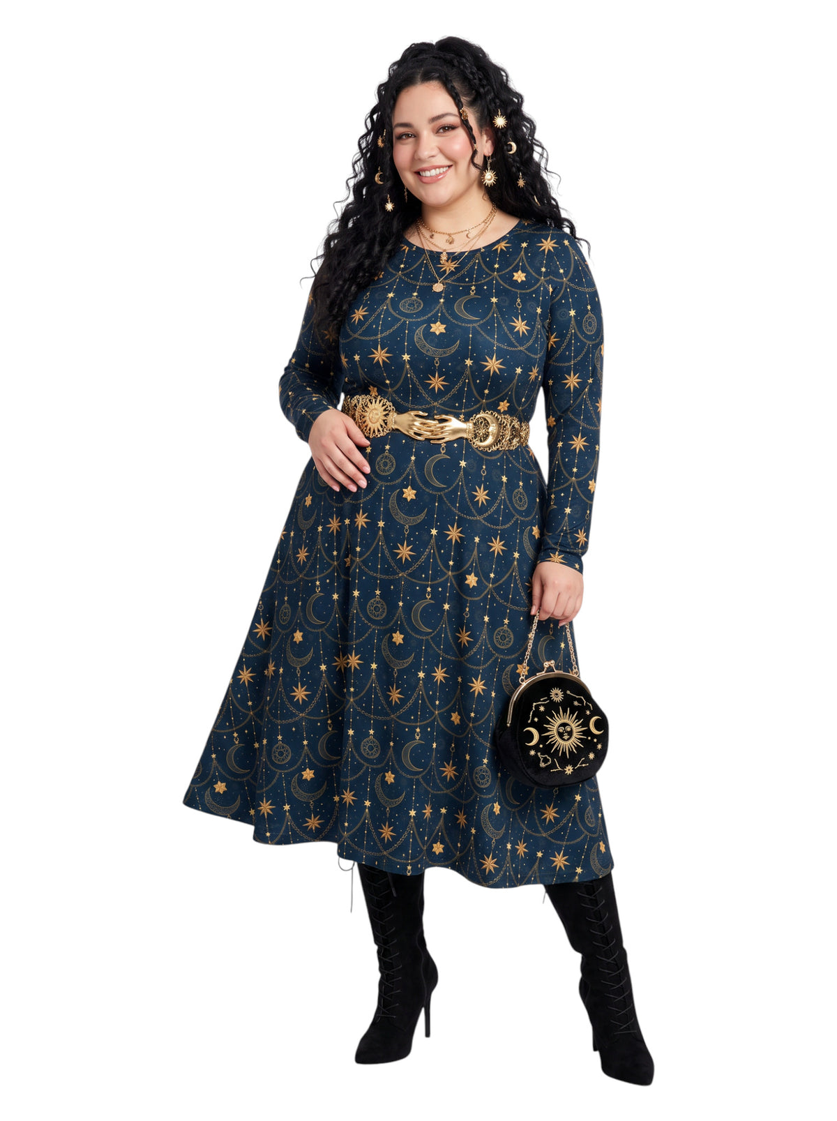 A woman modeling a long-sleeve navy blue midi dress with a gold celestial print of stars, moons, and constellations, styled with a wide gold belt and black knee-high boots against a plain white background.