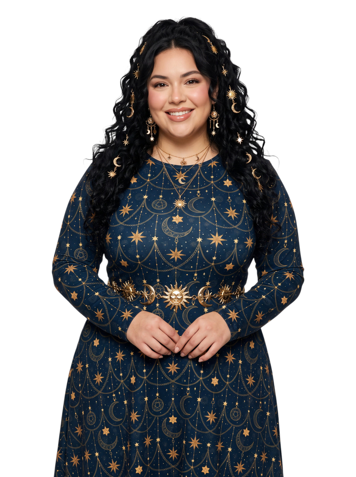 A woman with long, curly black hair wearing a dark navy blue long-sleeve dress decorated with gold celestial patterns of stars, moons, and suns, along with matching gold crescent moon headbands and gold hoop earrings, set against a plain white background.