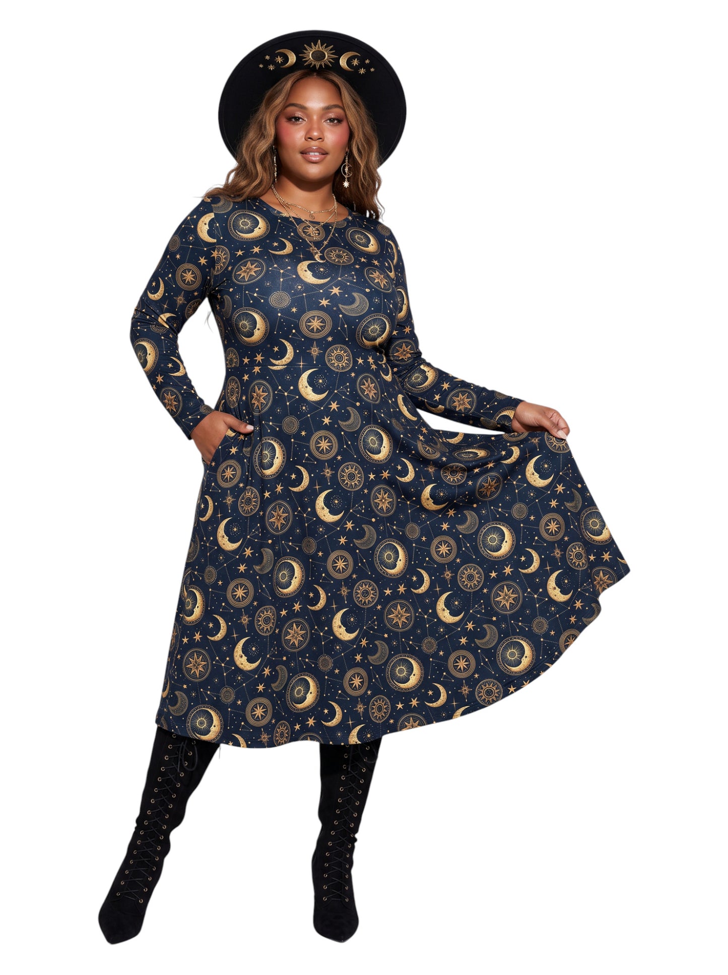 A woman modeling a long-sleeve midi dress with a celestial print of gold crescent moons and suns on a dark navy blue background. She is wearing a matching black wide-brim hat with a gold sun design, black lace-up boots, and posing against a solid white background.