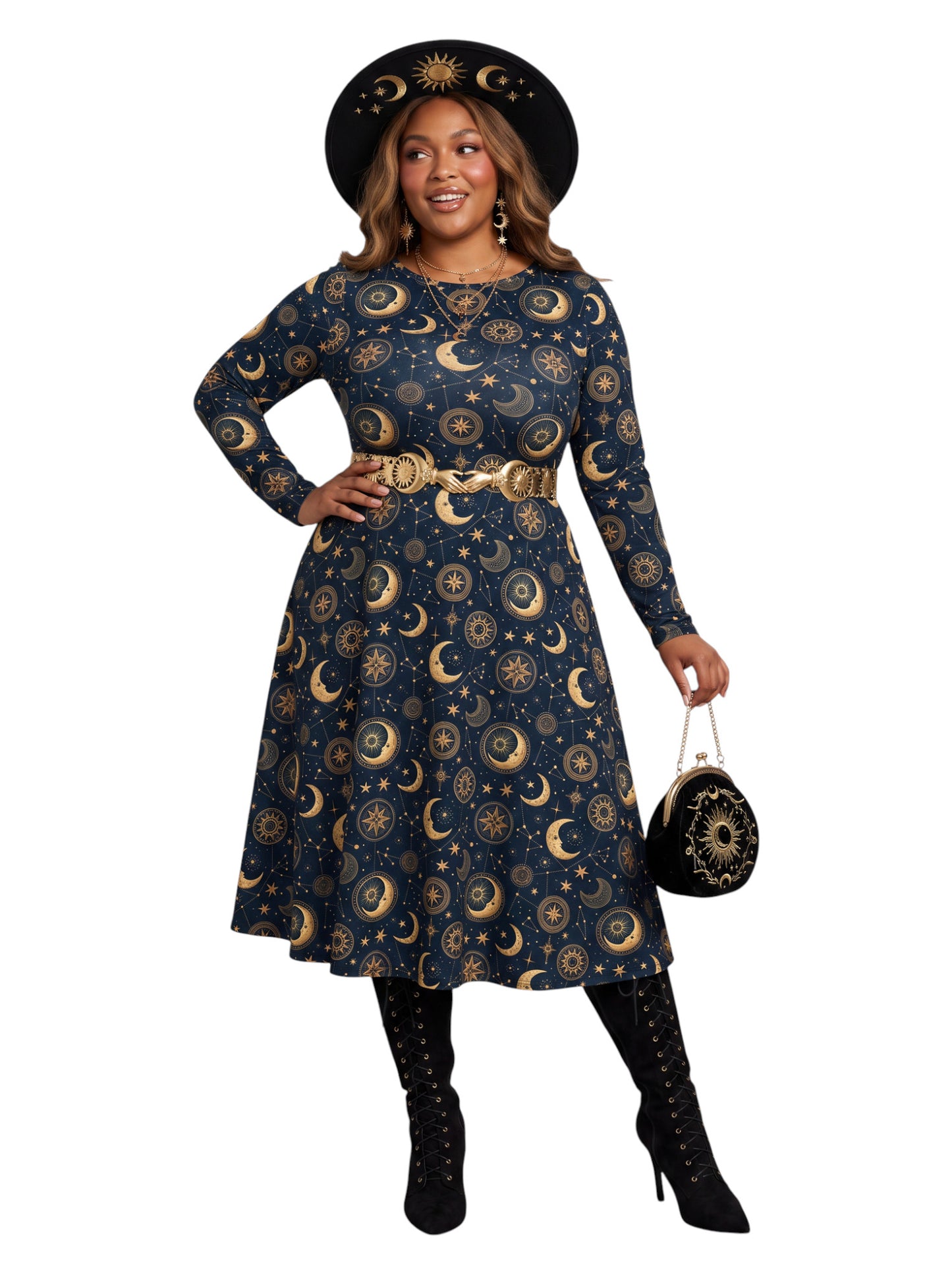 A woman modeling a long-sleeve midi dress with a celestial print of gold crescent moons and stars on a navy blue background, styled with a wide-brimmed black hat, gold belt, black lace-up boots, and a small black patterned handbag against a plain white background.