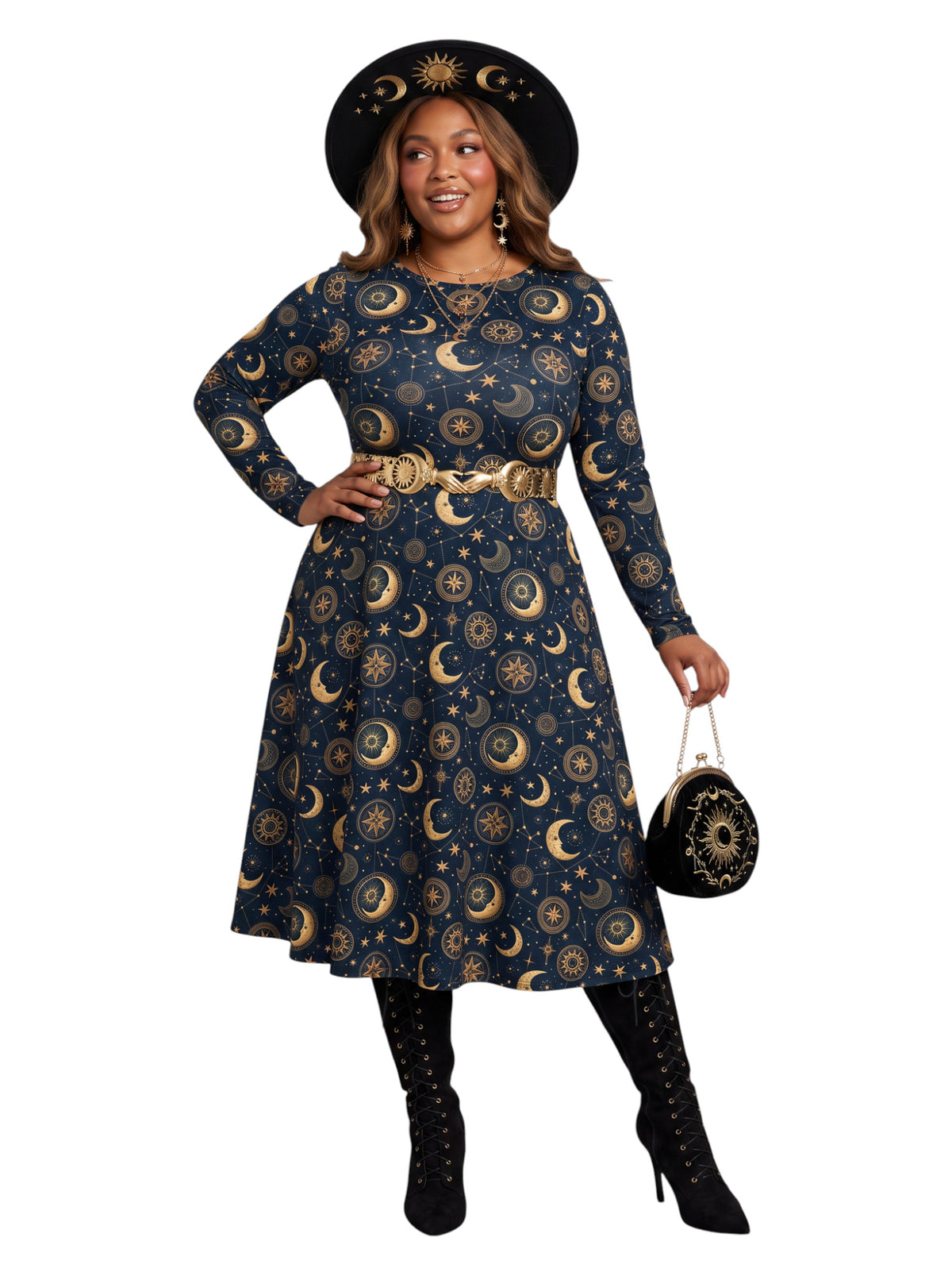 A woman modeling a long-sleeve midi dress with a celestial print of gold crescent moons and stars on a navy blue background, styled with a wide-brimmed black hat, gold belt, black lace-up boots, and a small black patterned handbag against a plain white background.