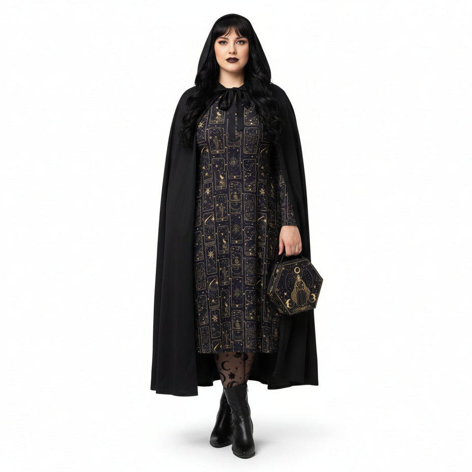 Woman wearing a black cape over a celestial tarot card print dress on a white background
