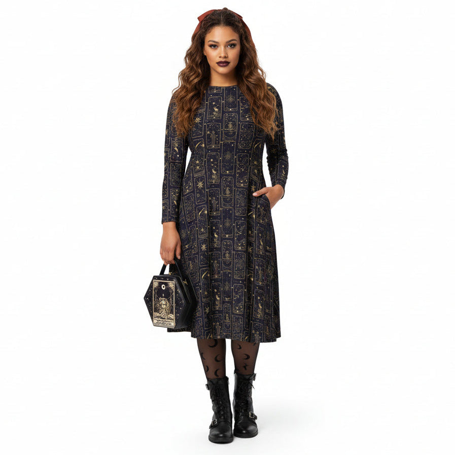 Woman wearing a celestial tarot card print dress with a matching bag on a white background