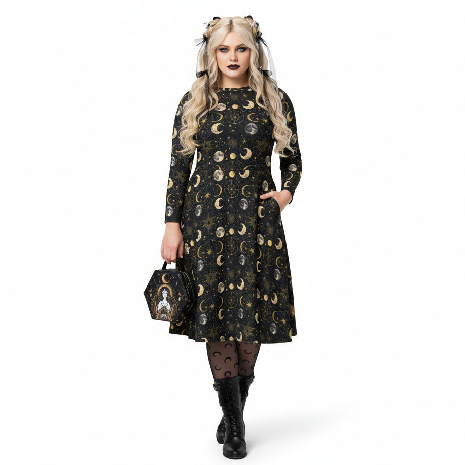 Woman wearing a black dress with celestial moon phase print holding a matching handbag on a white background