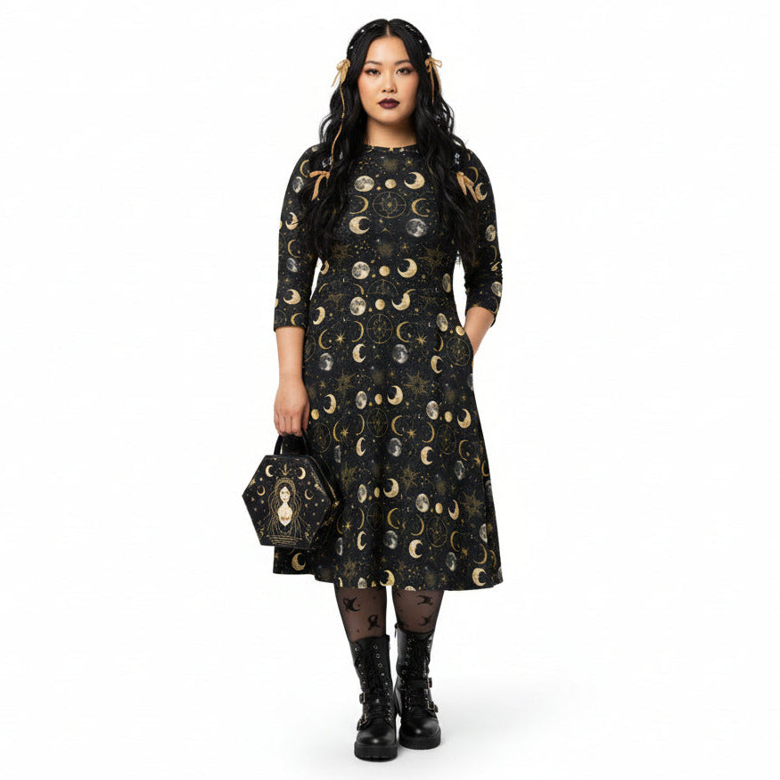 Woman wearing a black dress with gold moon phases on a white background
