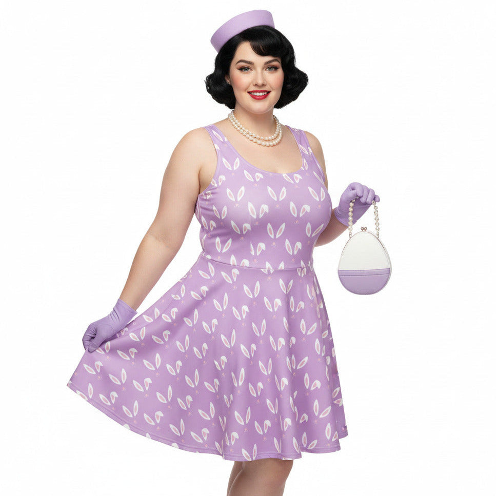 Curvy woman wearing a lavender purple plus size 1950s vintage style swing dress with white Easter bunny print, matching pillbox hat, and pearl necklace.
