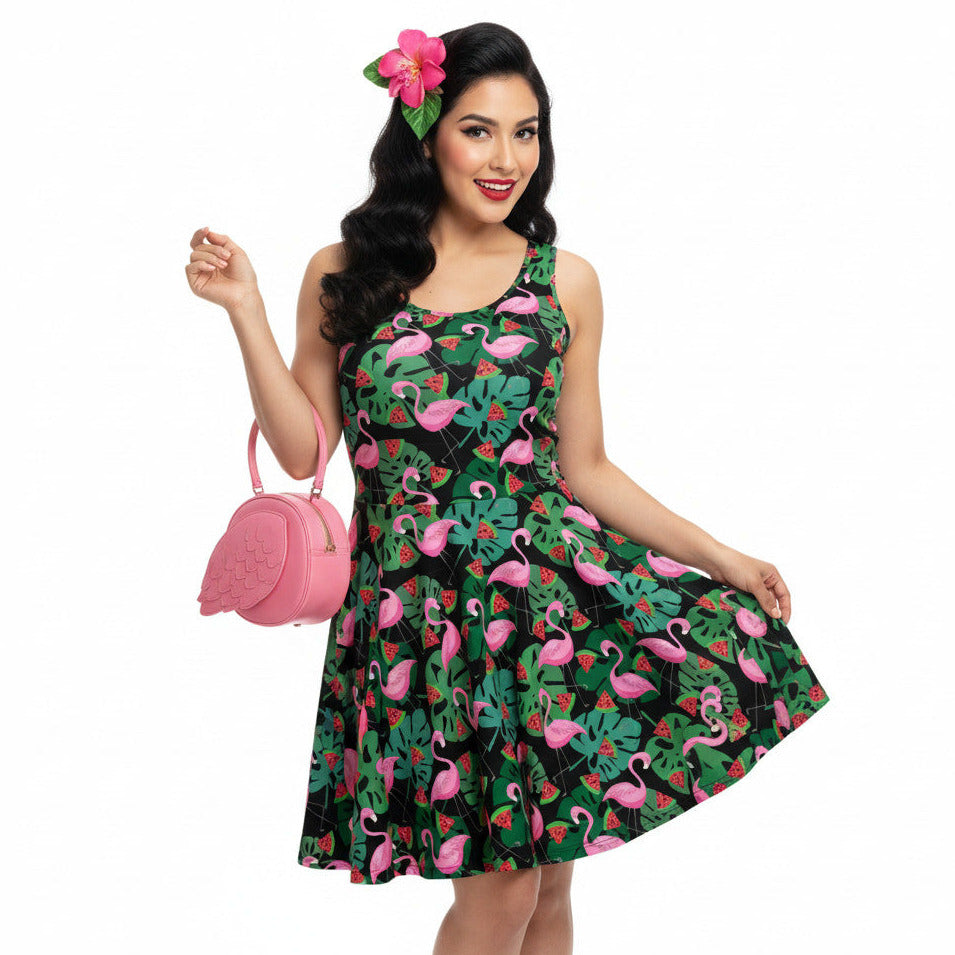 Woman wearing a 1950s vintage-inspired fit and flare swing dress with a tropical flamingo and watermelon print.