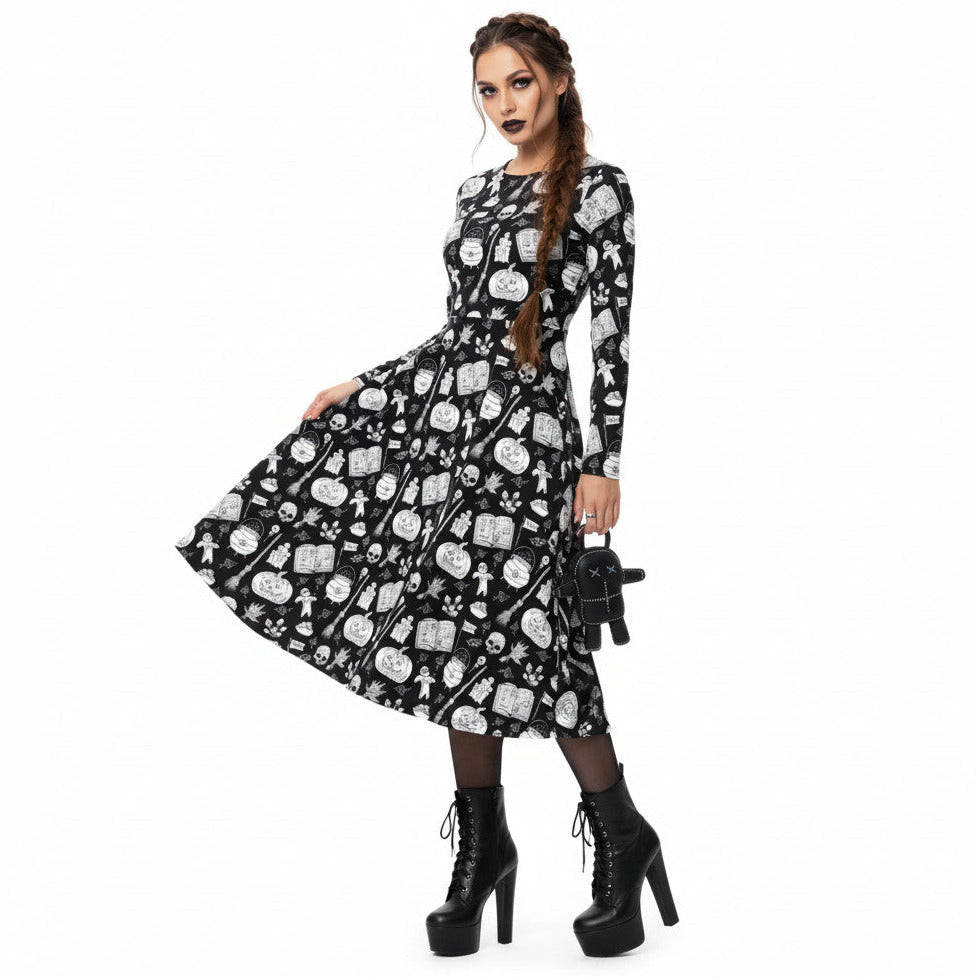 Woman wearing gothic long sleeve midi dress with black and white voodoo doll print and side pockets.