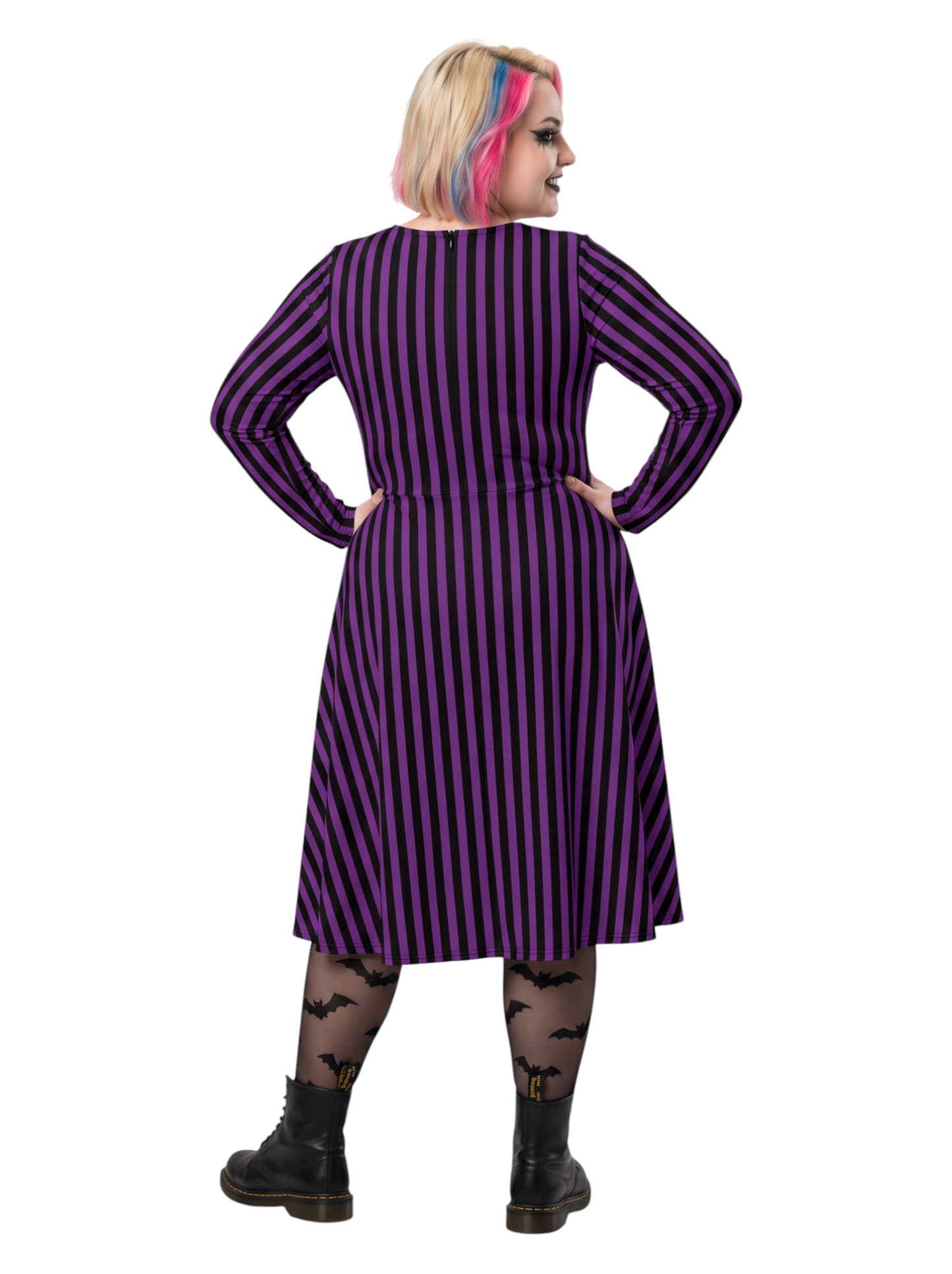 Plus size woman modeling gothic purple and black vertically striped long sleeve fit and flare midi dress with side pockets