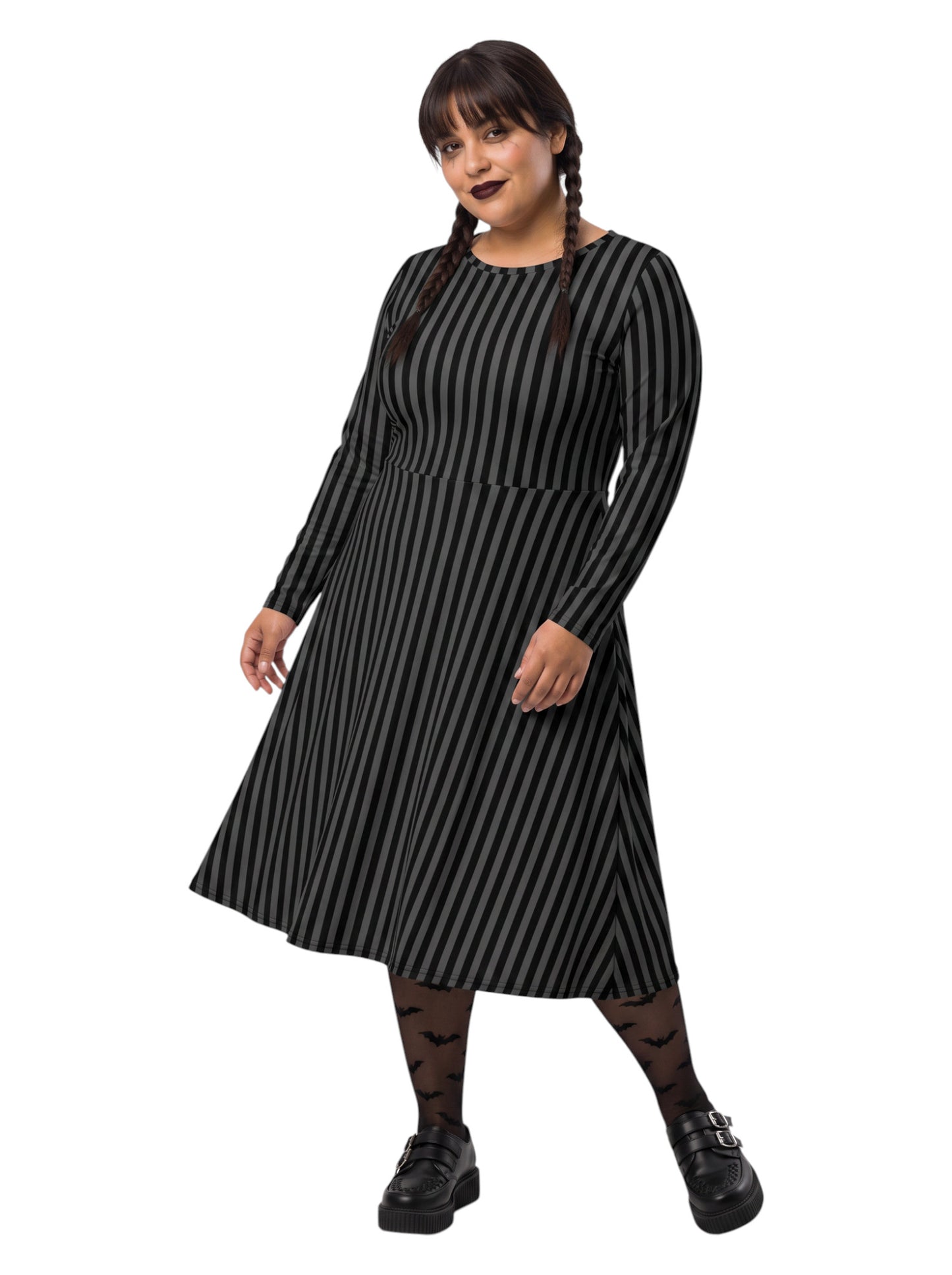 Plus size woman wearing a gothic grey and black vertically striped fit and flare midi dress with long sleeves, functional side pockets, and a scoop neckline.