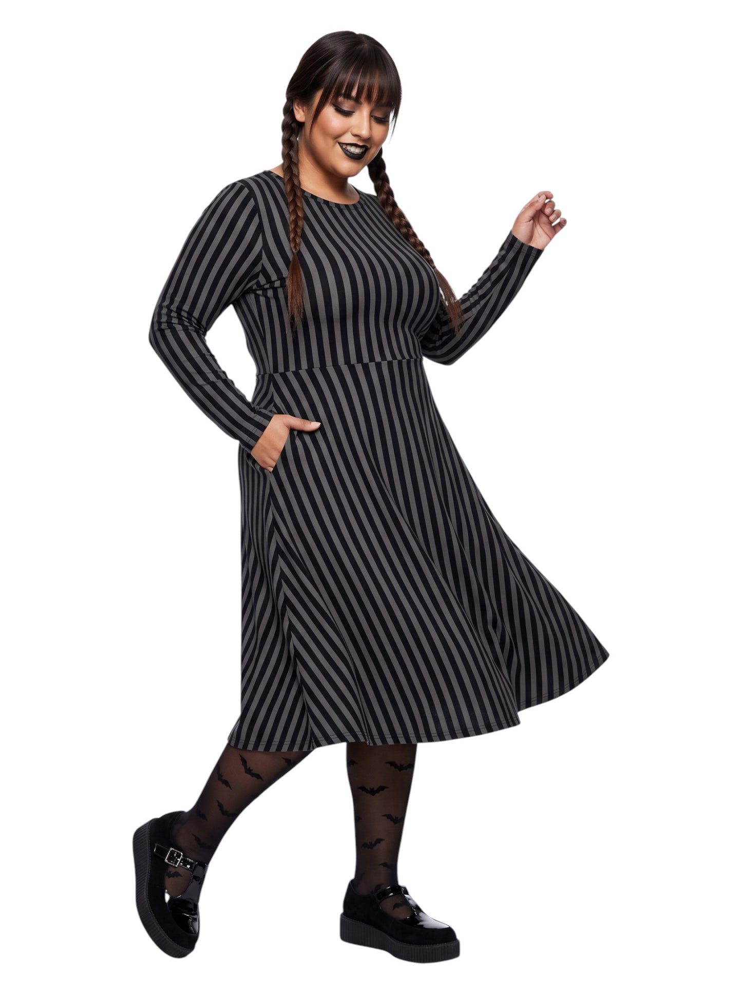 Plus size woman wearing a gothic grey and black vertically striped fit and flare midi dress with long sleeves, functional side pockets, and a scoop neckline.