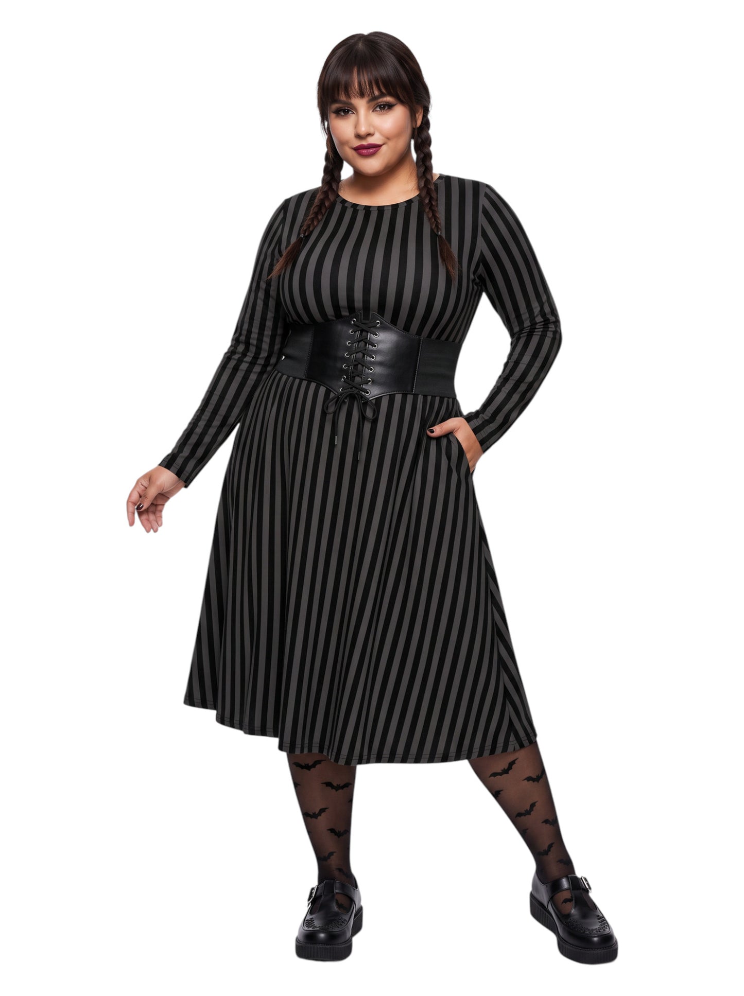 Plus size woman wearing a gothic grey and black vertically striped fit and flare midi dress with long sleeves, functional side pockets, and a scoop neckline.