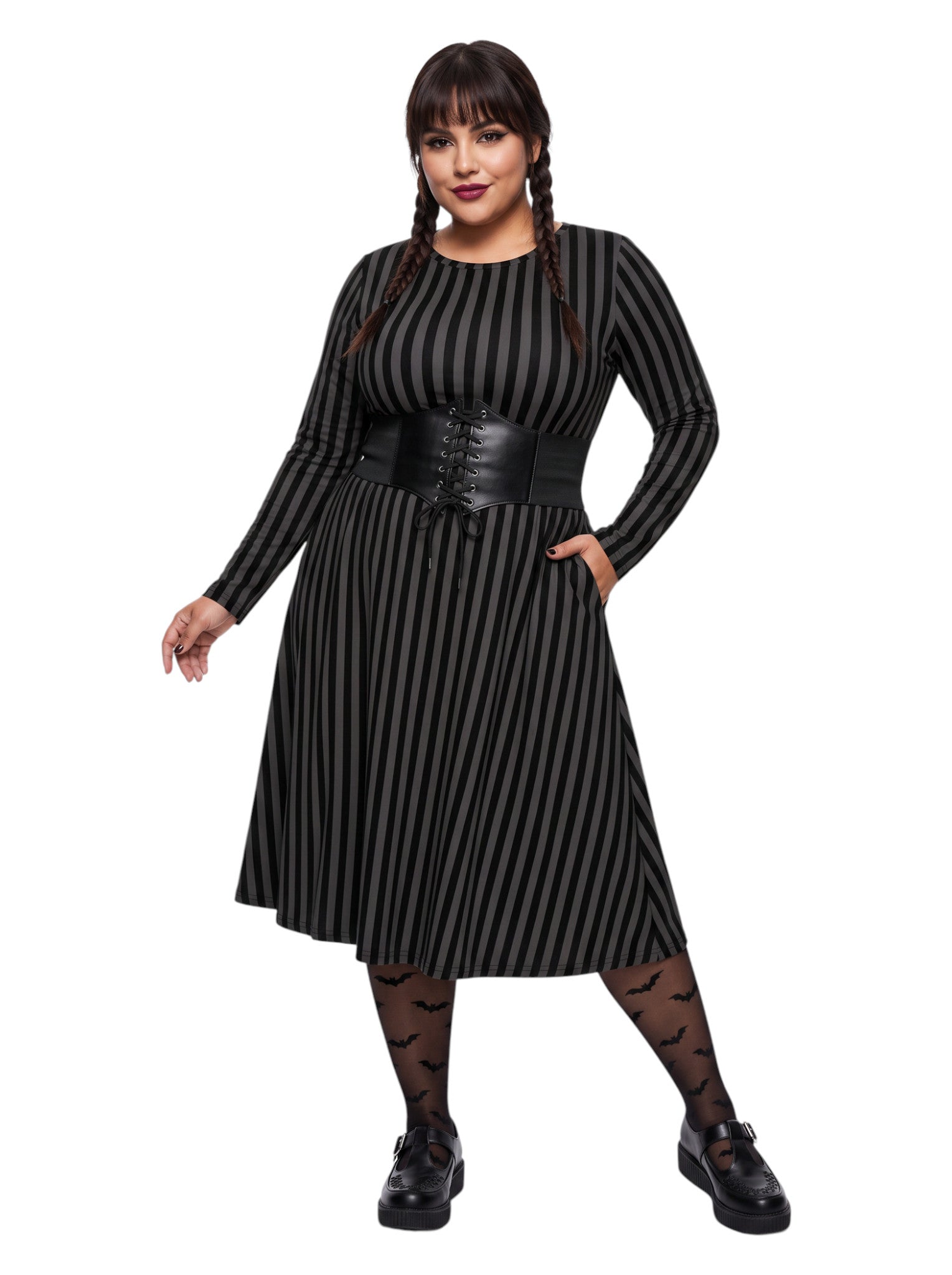 Plus size woman wearing a gothic grey and black vertically striped fit and flare midi dress with long sleeves, functional side pockets, and a scoop neckline.