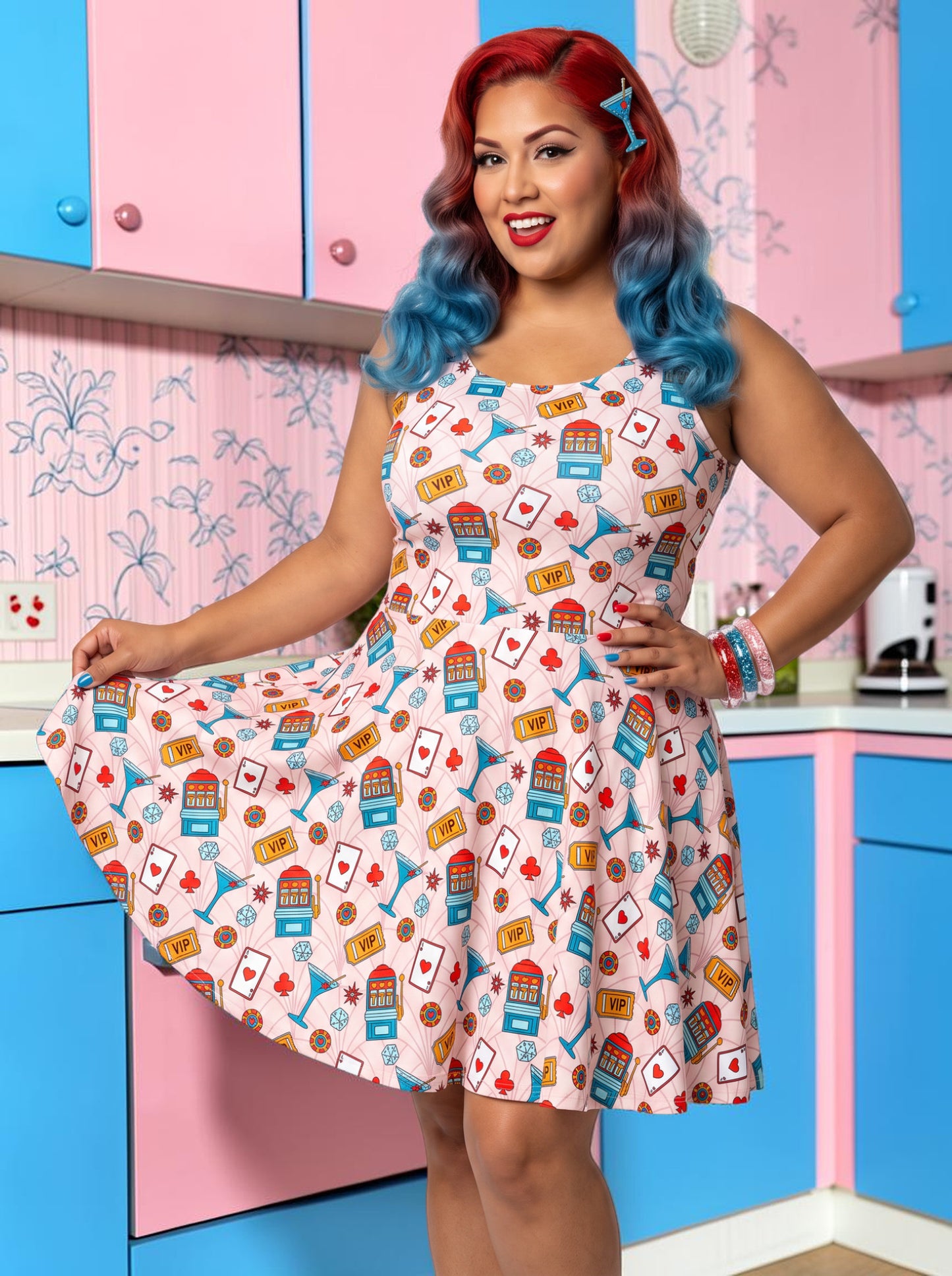 Plus-size model with red and blue hair wearing a pink retro casino print fit and flare dress featuring slot machines, playing cards, and blue martini glasses.