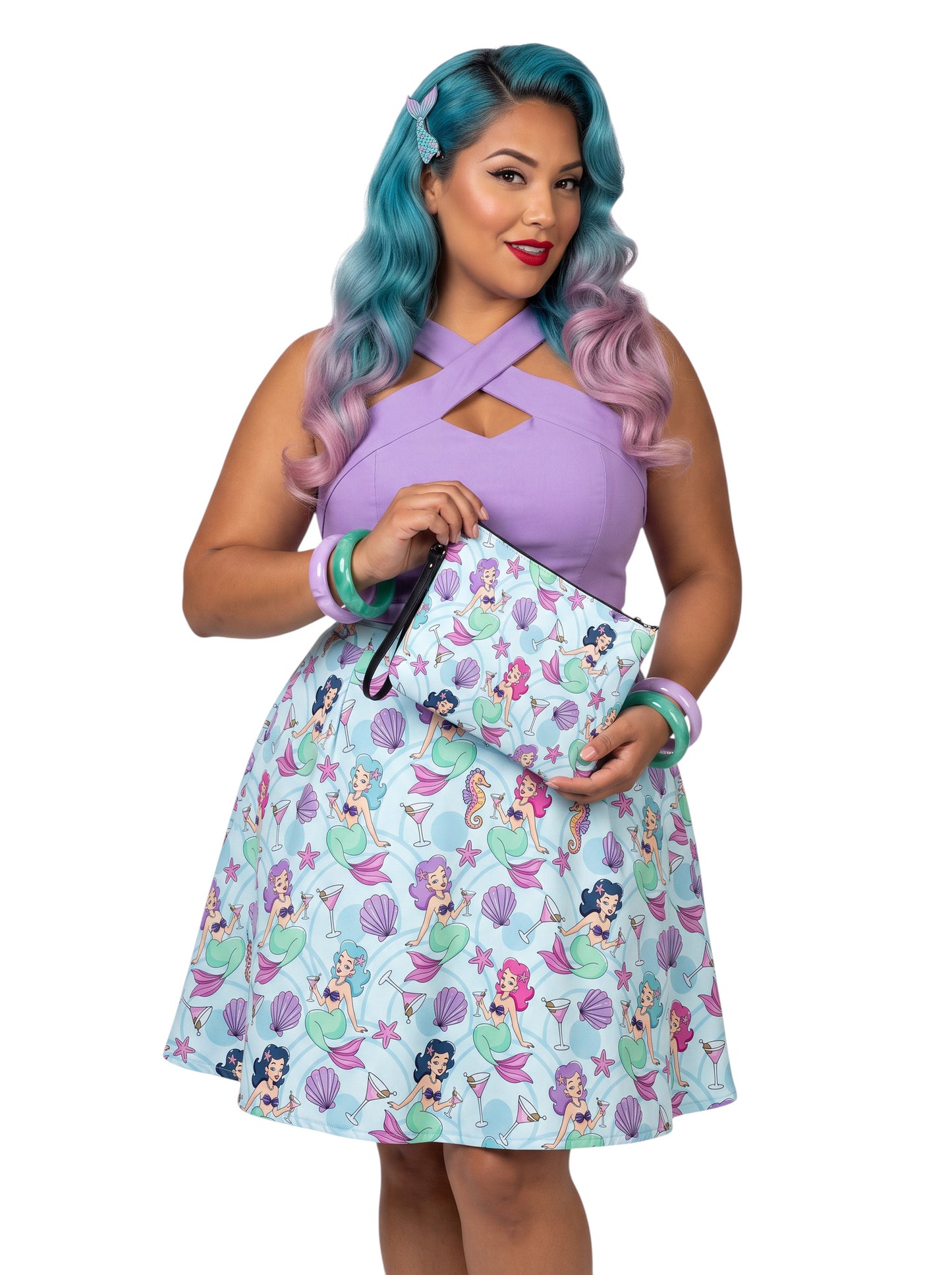 A woman wears as mermaids, martinis and seashells convertible clutch and crossbody bag in faux leather with adjustable strap.