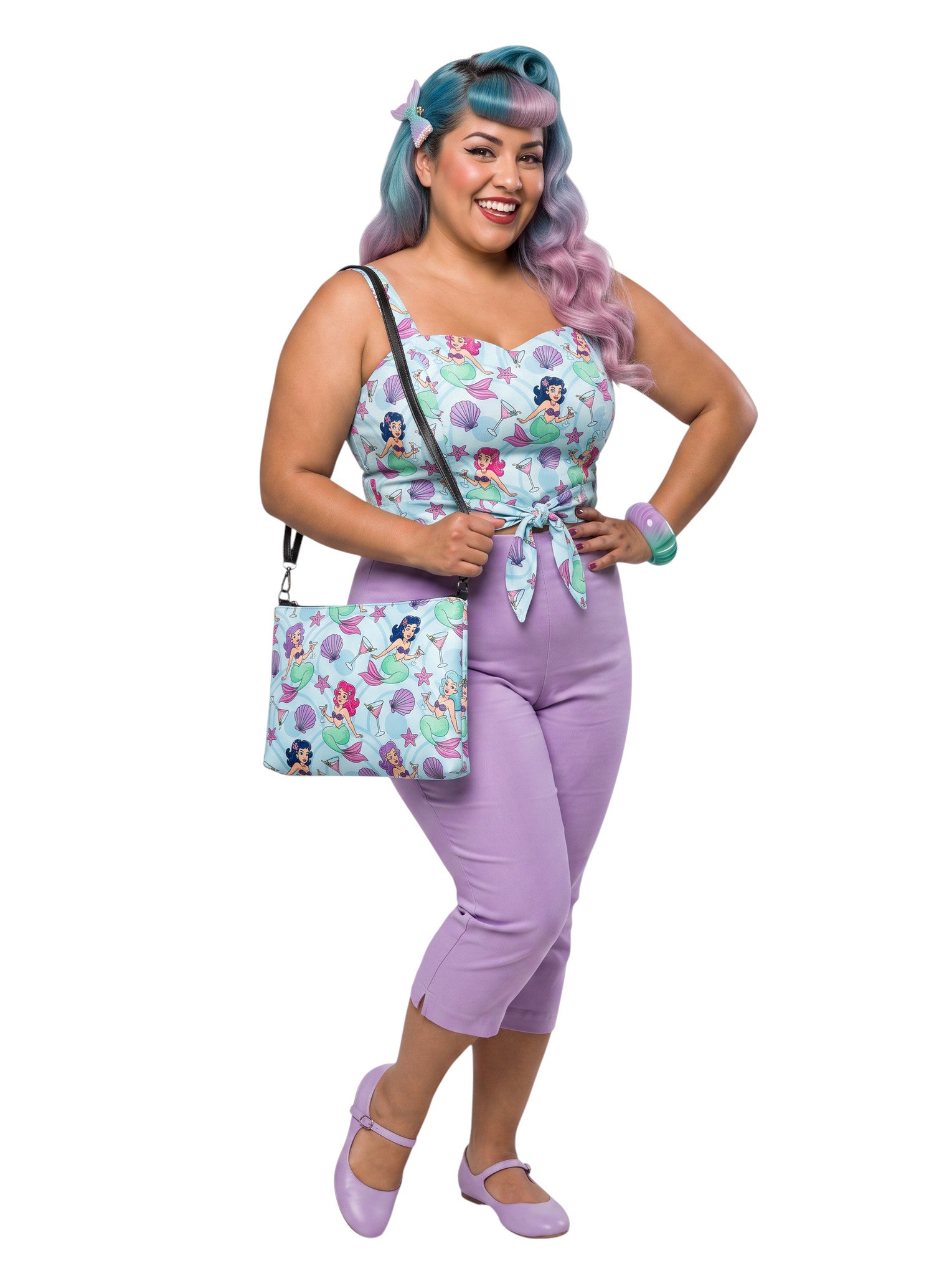 A woman wears as mermaids, martinis and seashells convertible clutch and crossbody bag in faux leather with adjustable strap.