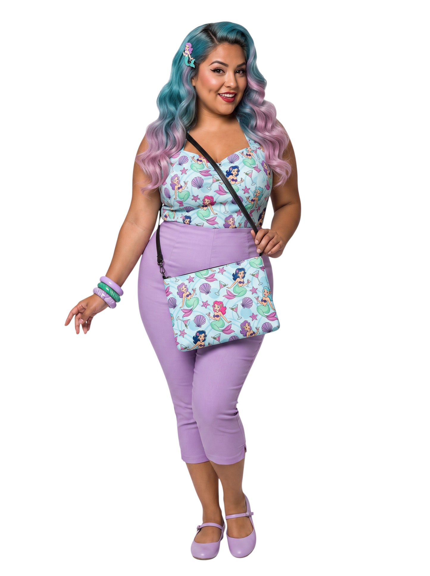 A woman wears as mermaids, martinis and seashells convertible clutch and crossbody bag in faux leather with adjustable strap.