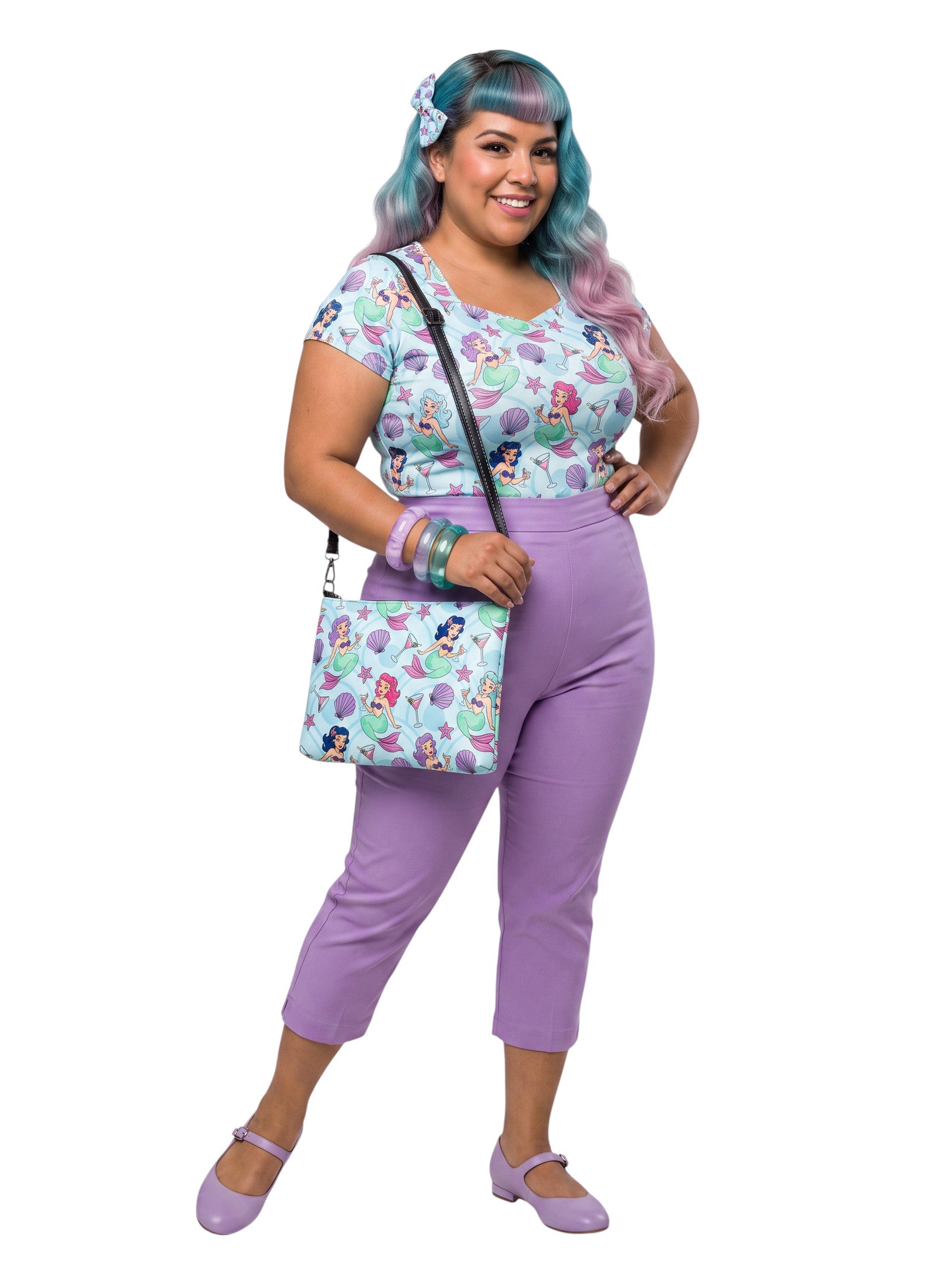 A woman wears as mermaids, martinis and seashells convertible clutch and crossbody bag in faux leather with adjustable strap.