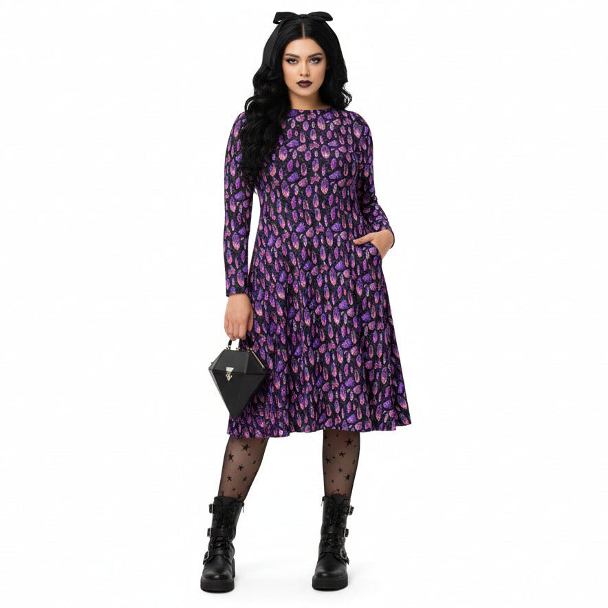 Woman wearing a purple crystal print  dress with a floral pattern on a white background