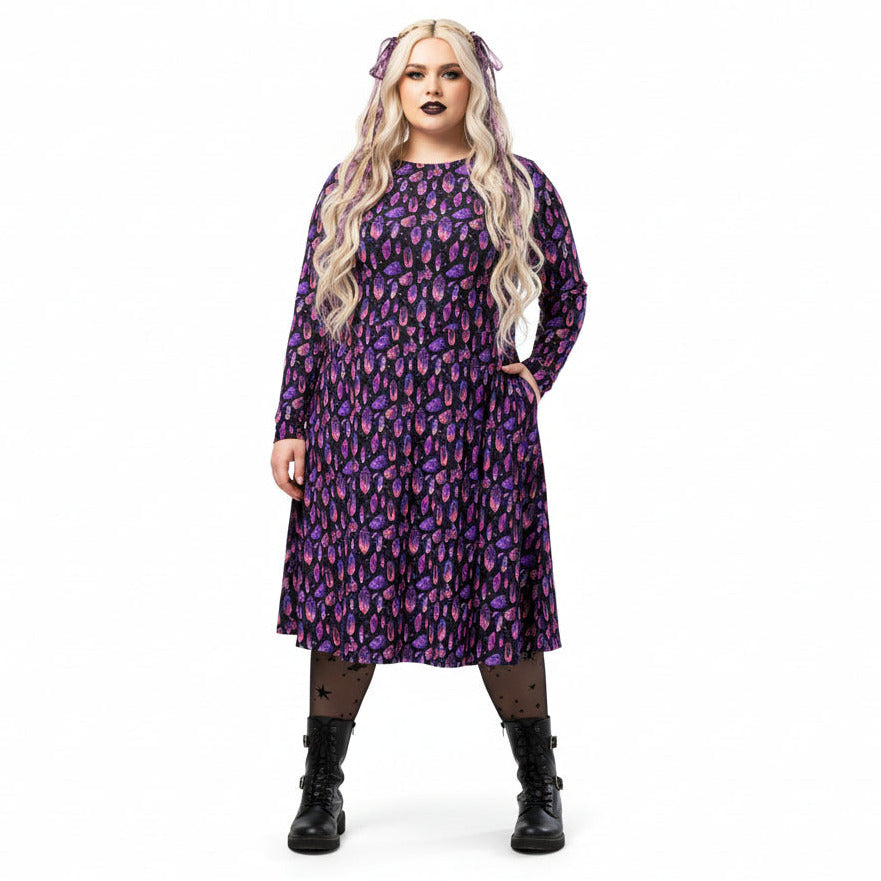 Woman wearing a purple mystical crystal print dress on a white background