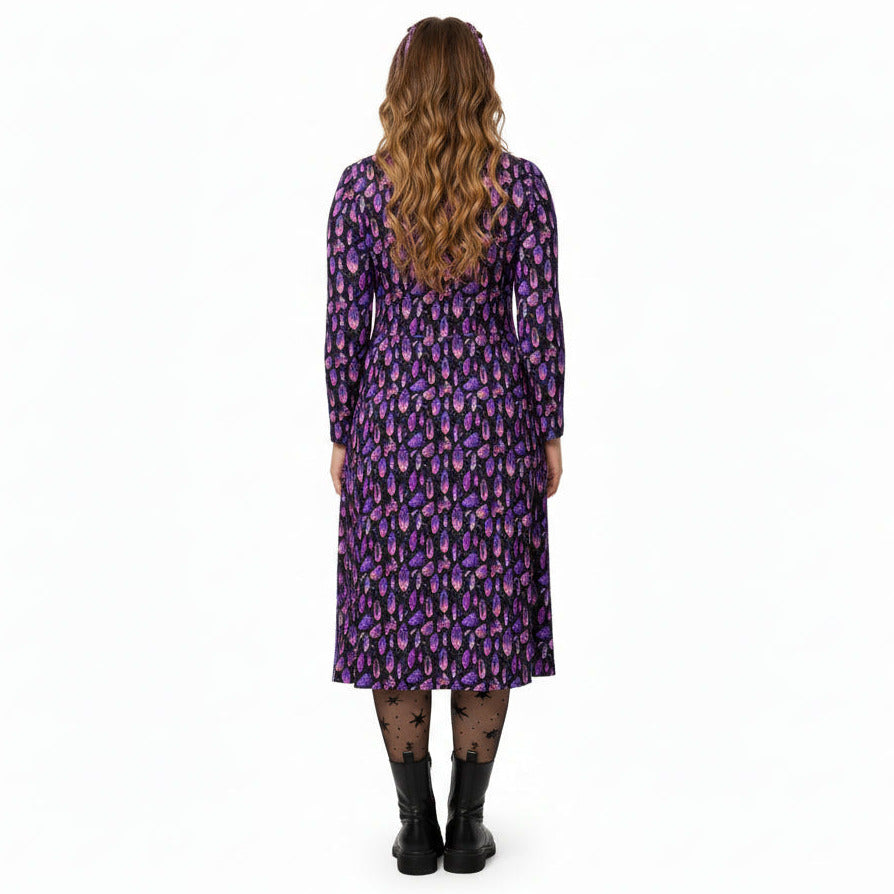 Woman wearing a purple patterned dress on a white background
