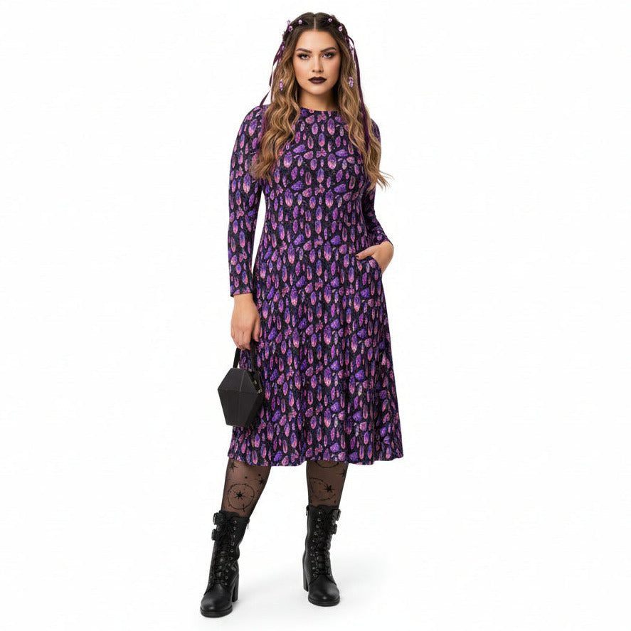 Woman wearing a purple mystical crystal print dress on a white background